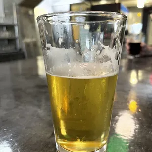 a glass of beer on a bar