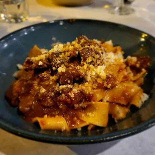 Pappardelle al Ragù di Cinghiale: Fresh wide ribbon pasta, slow braised wild boar ragu, red wine, rosemary, spices, tomato, parmigiano