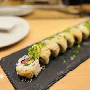 a sushi roll on a slate plate