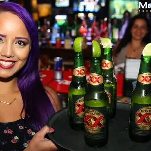 a woman holding a tray of beer