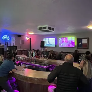 a large group of people sitting at a bar