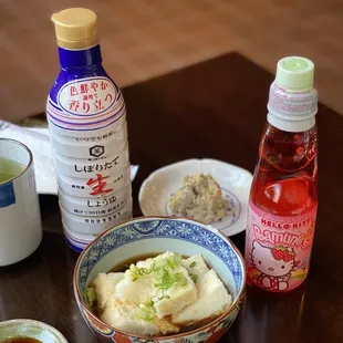 a bowl of mashed potatoes and sauces on a table
