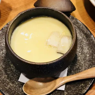 a bowl of soup on a plate with a spoon