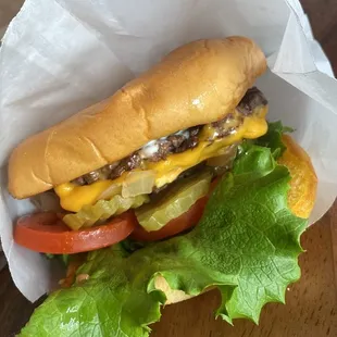 a cheeseburger with lettuce and tomato