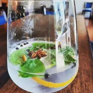 a glass of water with lemon, anise, and anise star anise