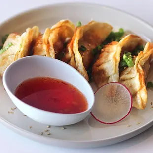 potstickers- fried pork dumplings.  Served with sweet chili sauce, scallions, and sesame seeds.
