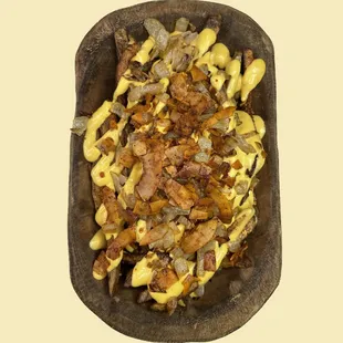 Love Explosion Fries - French fries smothered in cheese sauce topped with grilled onions and flakin' bakin'