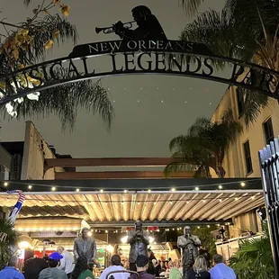 a crowd of people walking through a gated entrance