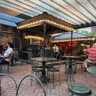 people sitting at tables under an awning