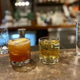 two glasses of alcohol on a bar counter