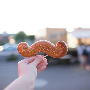 Foreground: An Original Mustache Pretzel Background: A blurry food truck