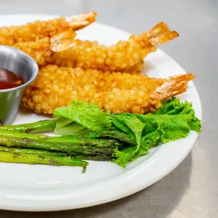 a plate of food with asparagus and dipping sauce