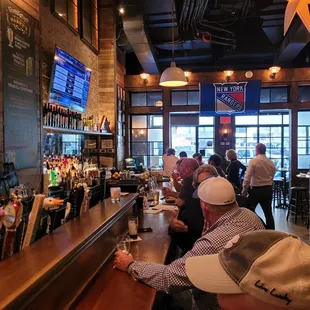 a bar with people sitting at the bar