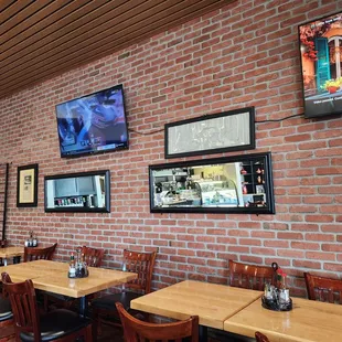 a brick wall with multiple pictures on it