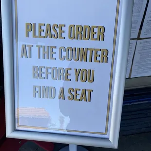 a sign that reads please order at the counter before you find a seat
