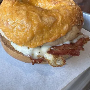 a breakfast sandwich with bacon and cheese