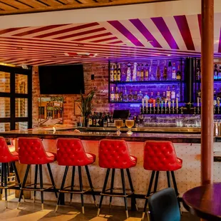 a bar with red bar stools