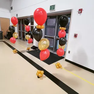 Red, gold, and black helium filled balloons. School dance balloon decorations.
