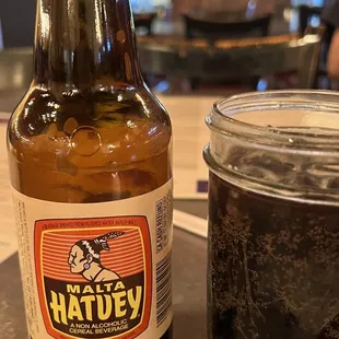 a bottle of hatley's root beer next to a jar of root beer