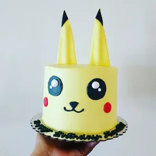 a hand holding a pokemon cake