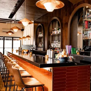 a bar with stools and a bar counter