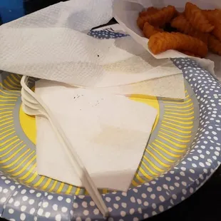 a plate with a fork, napkin, and some fried food