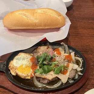 a skillet with a sandwich and a bowl of soup