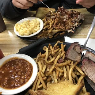 ows a plate of ribs, french fries, macaroni, and cheese