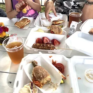 a woman eating a sandwich and a hot dog