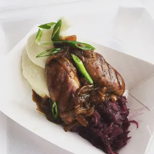 "Bangers &amp; Mash" British style sausages served over mashed potatoes red cabbage and topped with BEER ONIONS