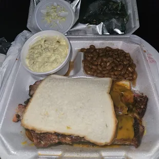 a sandwich, beans, and coleslaw