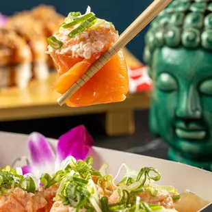  person holding chopsticks over a box of sushi