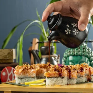 omeone pouring tea over a plate of sushi