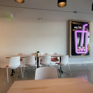 a table and chairs in front of a painting