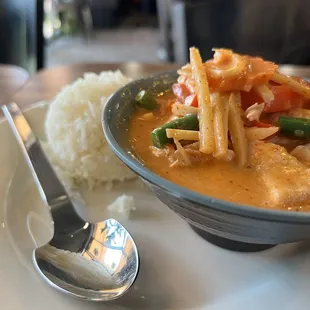 a plate of food with rice and a spoon