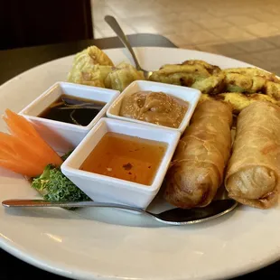 a plate of food with dipping sauces