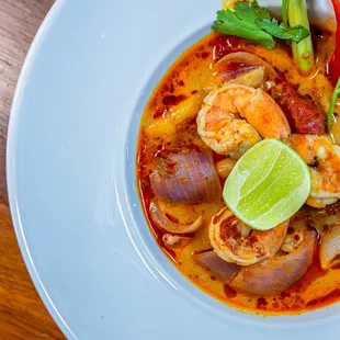 a bowl of soup with shrimp and vegetables