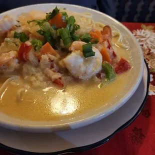 a bowl of soup with shrimp and vegetables