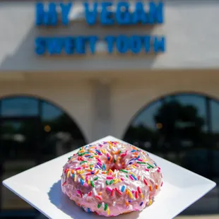 a pink frosted donut with sprinkles