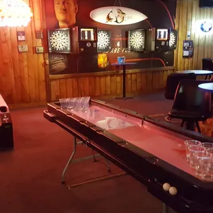 a shuffle table and a row of shot glasses