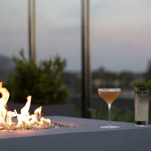 a glass of wine and a fire pit