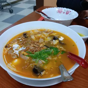 Chicken soup with glass noodles. Empty bowl for sharing.