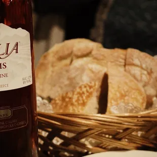 a basket of bread and a bottle of wine