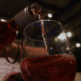 a person pouring wine into a glass