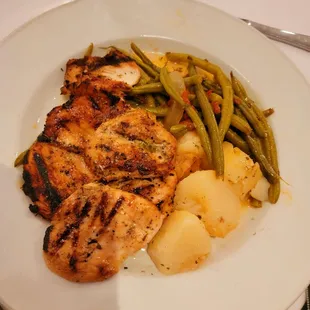 a plate of chicken, potatoes, and green beans
