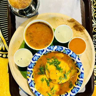 Idli dipped in sambar, with a side of various chutneys and really good strong filter coffee.