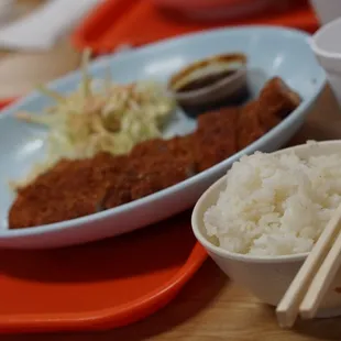 a plate of rice and chopsticks