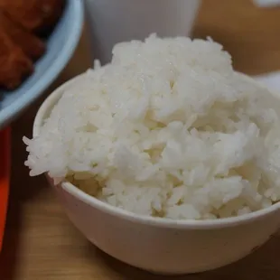 a bowl of rice and a plate of fried chicken