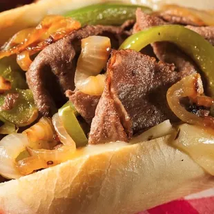 a steak sandwich with peppers and onions