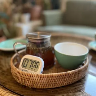 a wicker tray with a cup of tea and a jar of honey